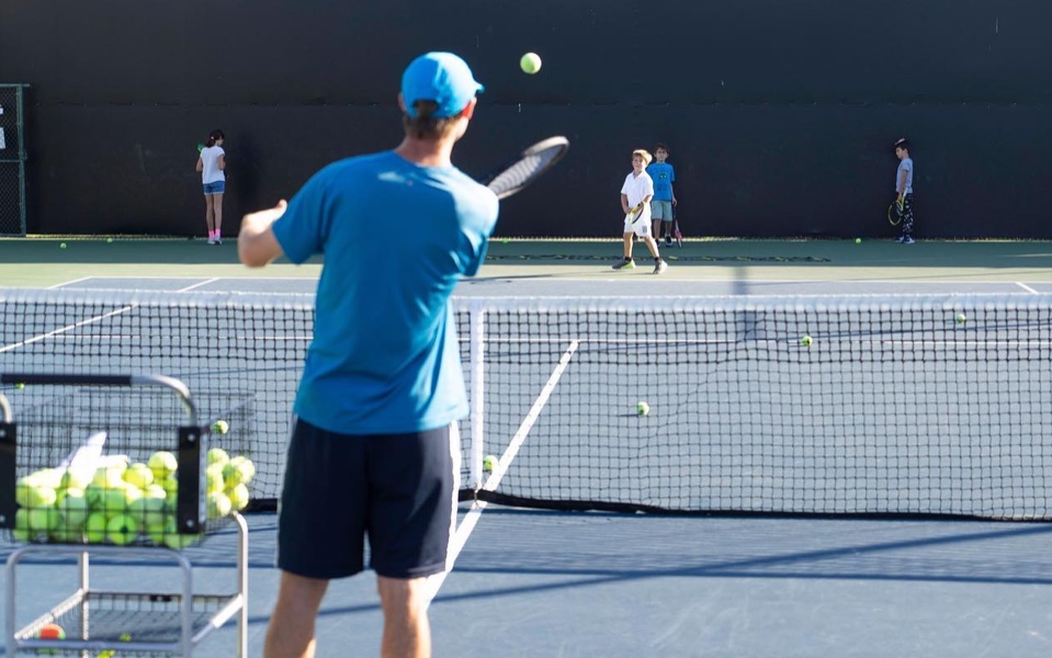 Adult and kids playing tennis at the Riviera Country Club, Palisades, California